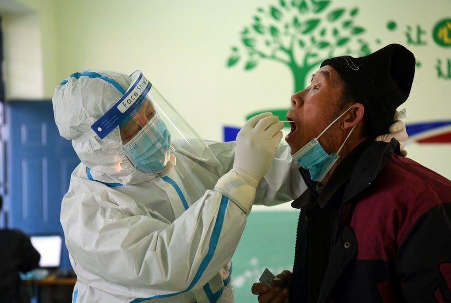 covid19-rural-china A medical worker collects a swab sample from a resident at a COVID-19 testing site in Baiwangzhuang Village of Jingxing County, Shijiazhuang, capital of north China's Hebei Province, Jan. 20, 2021. (Credit: Xinhua/Jin Liangkuai)